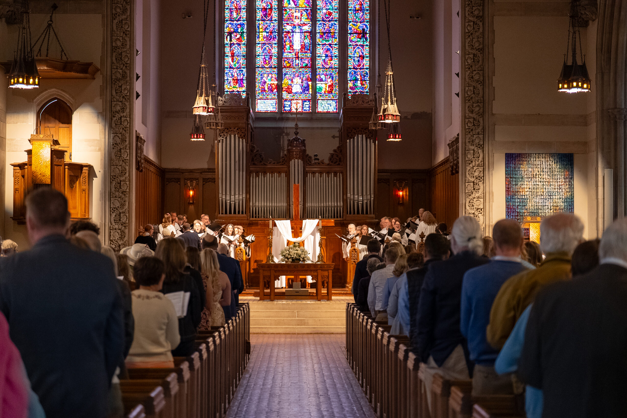 Easter worship at House of Hope, with the congregation facing the cross and stained glass