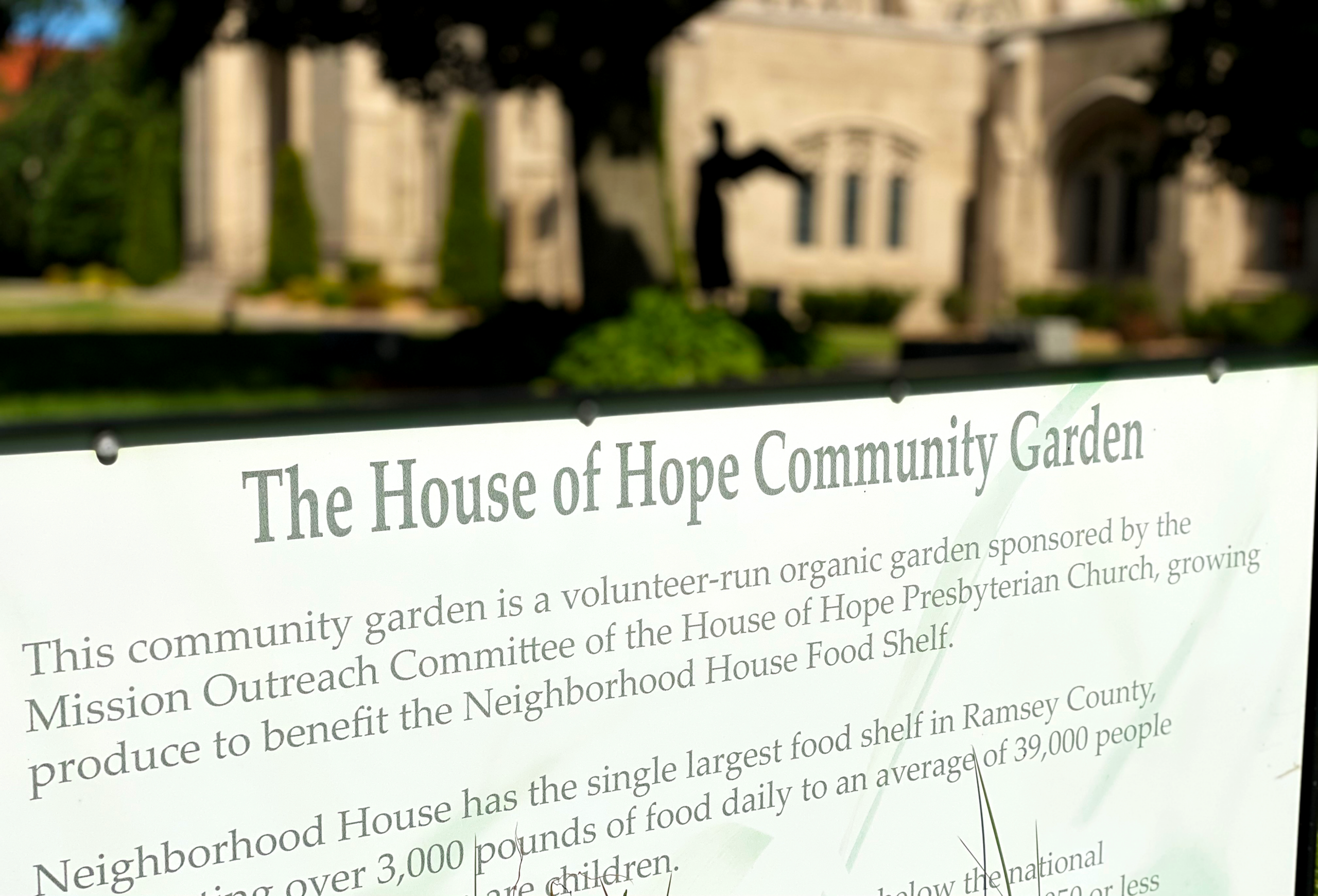 House of Hope Community Garden sign describing fresh produce grown for Neighborhood House Food Shelf.
