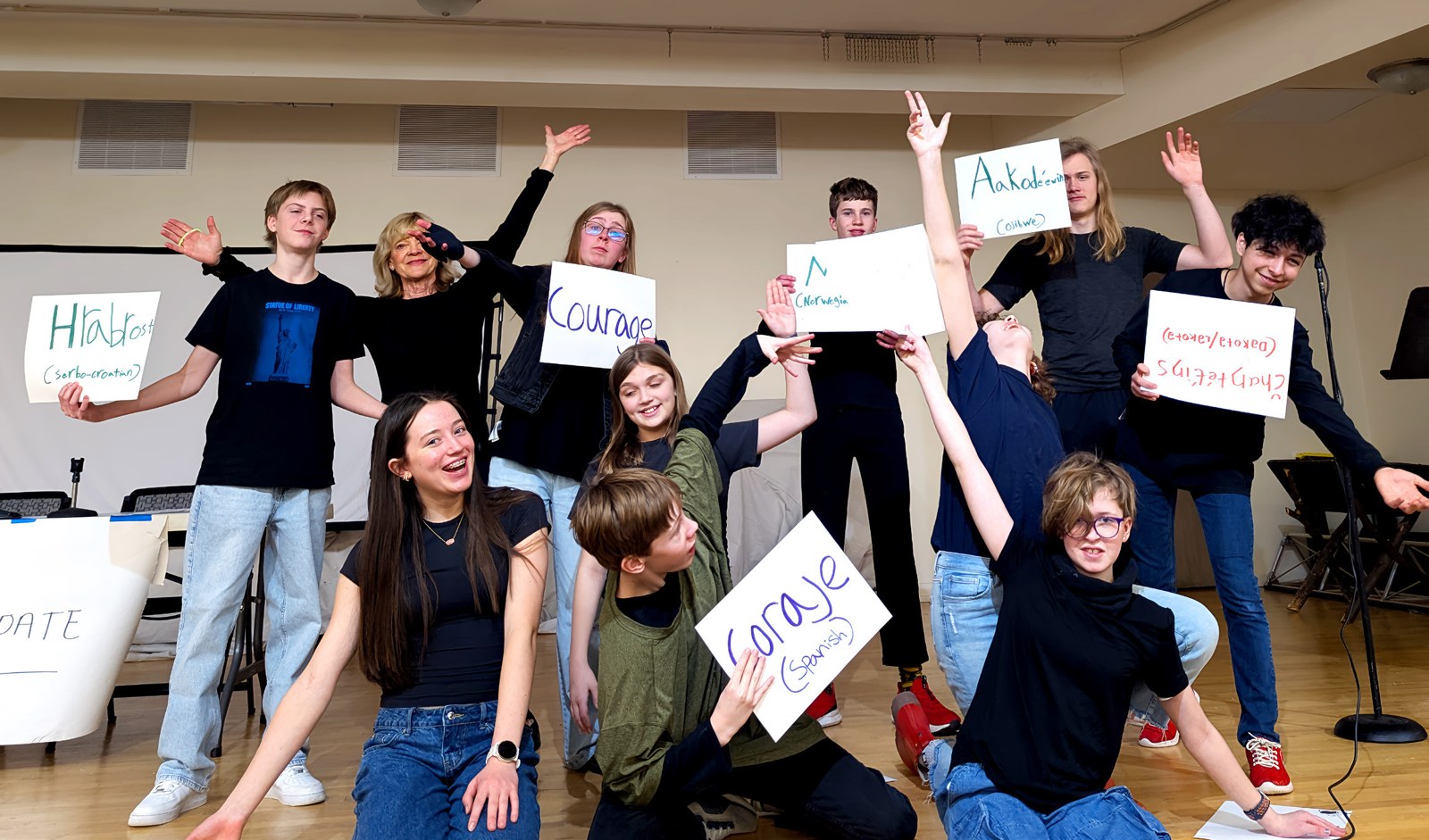 Young people pose together, holding signs that name their gifts and strengths.